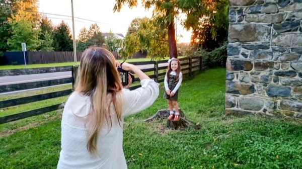 Mom taking photo of daughter